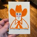 hand painted illustration in orange of a man wearing a large cowboy hat
