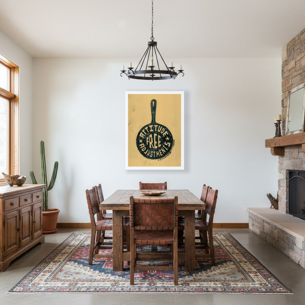 dining room scene with western flair showing the artwork of hand lettered phrase "free attitude adjustments" in the silhouette of a frying pan by western artist CJ Hughes